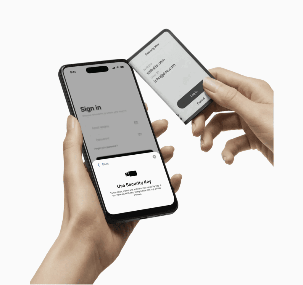Handen gebruiken de Ledger Stax hardware wallet met E Ink-touchscreen om veilig in te loggen via NFC op een smartphone, toont de functionaliteit als beveiligingssleutel
